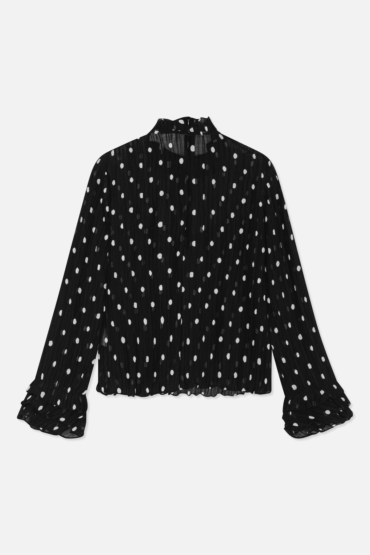Back view of a sheer black blouse with irregular white dots, a high neck, long sleeves and ruffled cuffs.