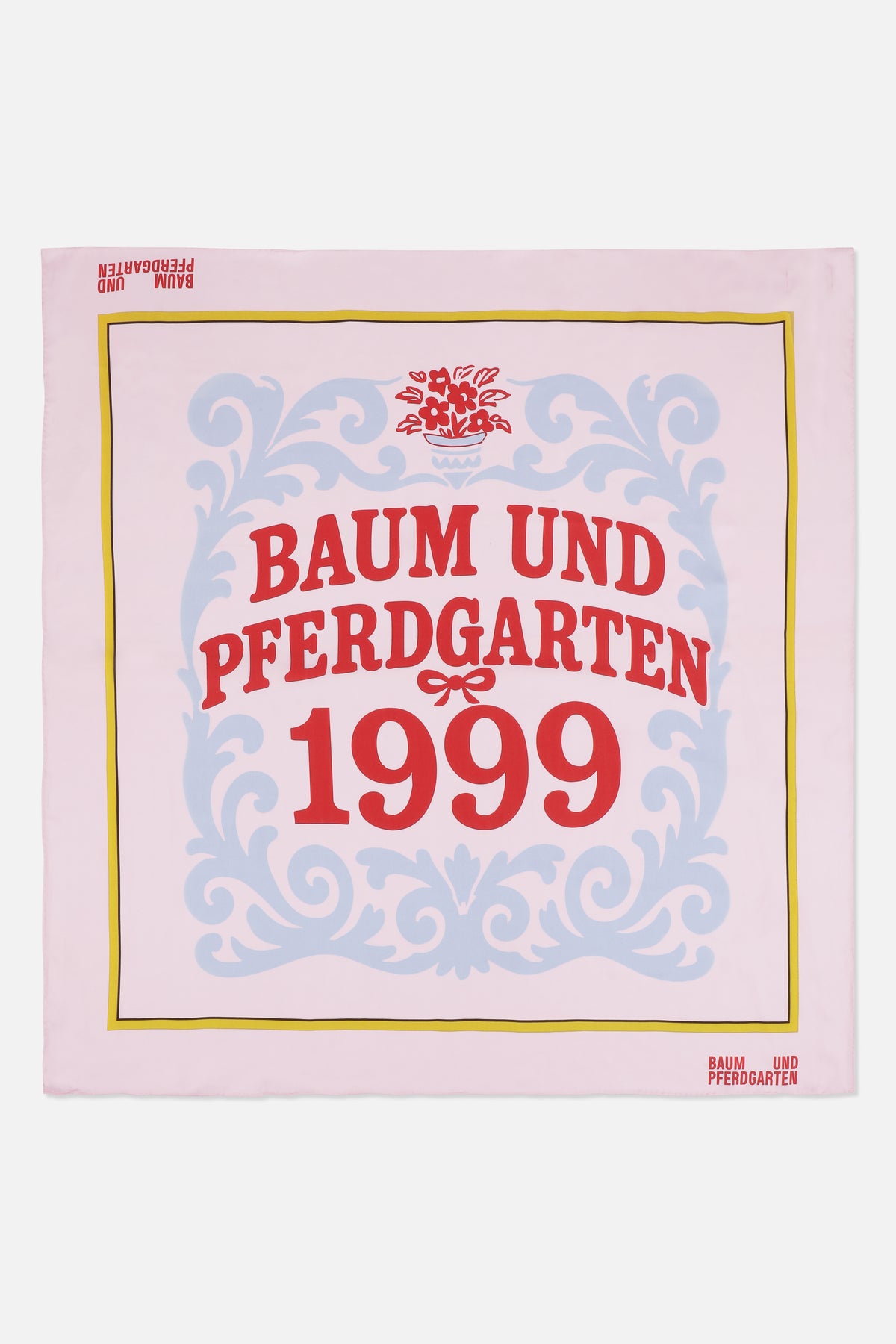 Pale pink square scarf with blue ornamental scrollwork, a yellow border and red Baum und Pferdgarten 1999 lettering