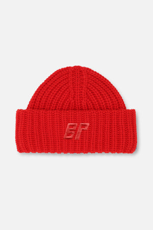 Close-up of a red chunky-knit beanie with a folded cuff and tonal embroidered BP monogram.