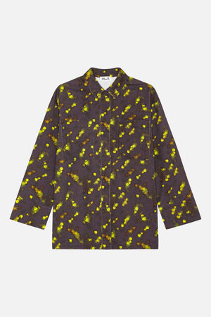 Vue de face d'une chemise à col et manches longues, dotée de deux poches plaquées, en tissu gris charbon parsemé d'un imprimé floral lumineux jaune et vert.