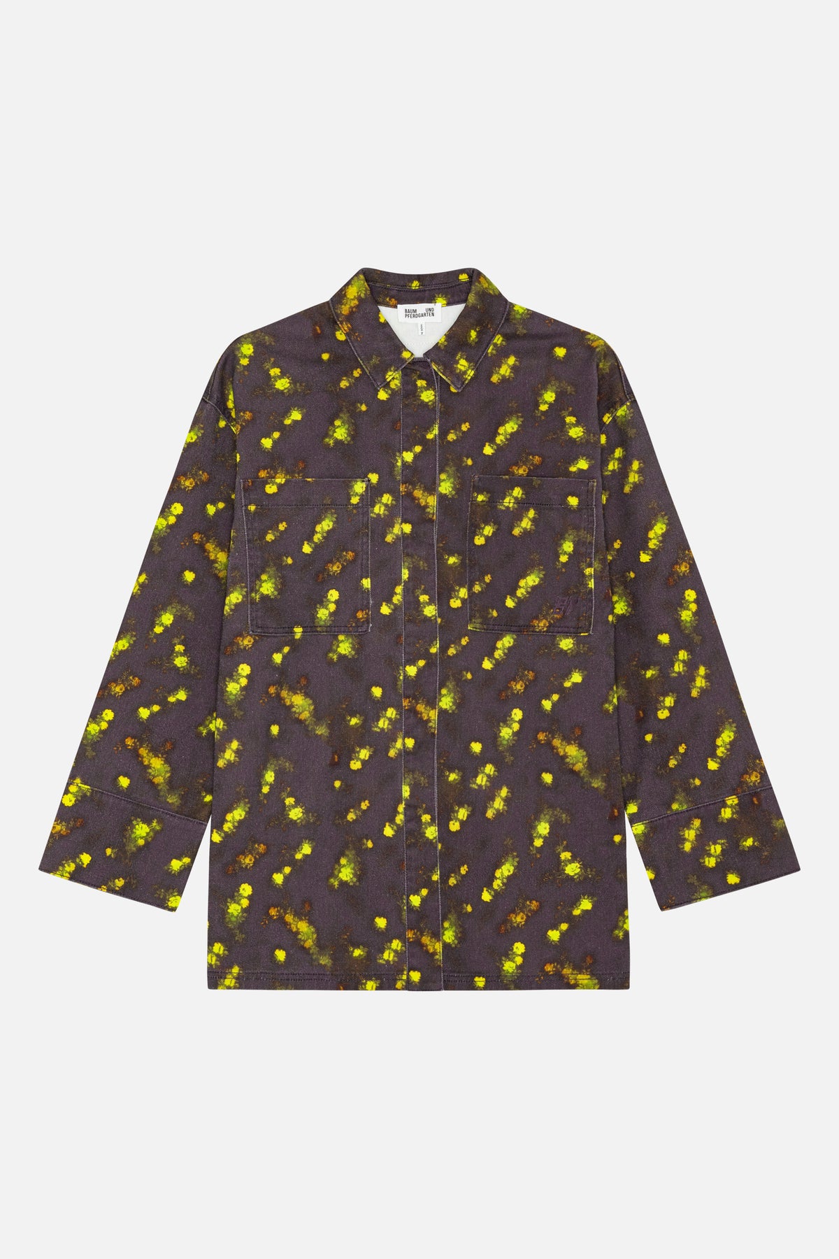 Vue de face d'une chemise à col et manches longues, dotée de deux poches plaquées, en tissu gris charbon parsemé d'un imprimé floral lumineux jaune et vert.