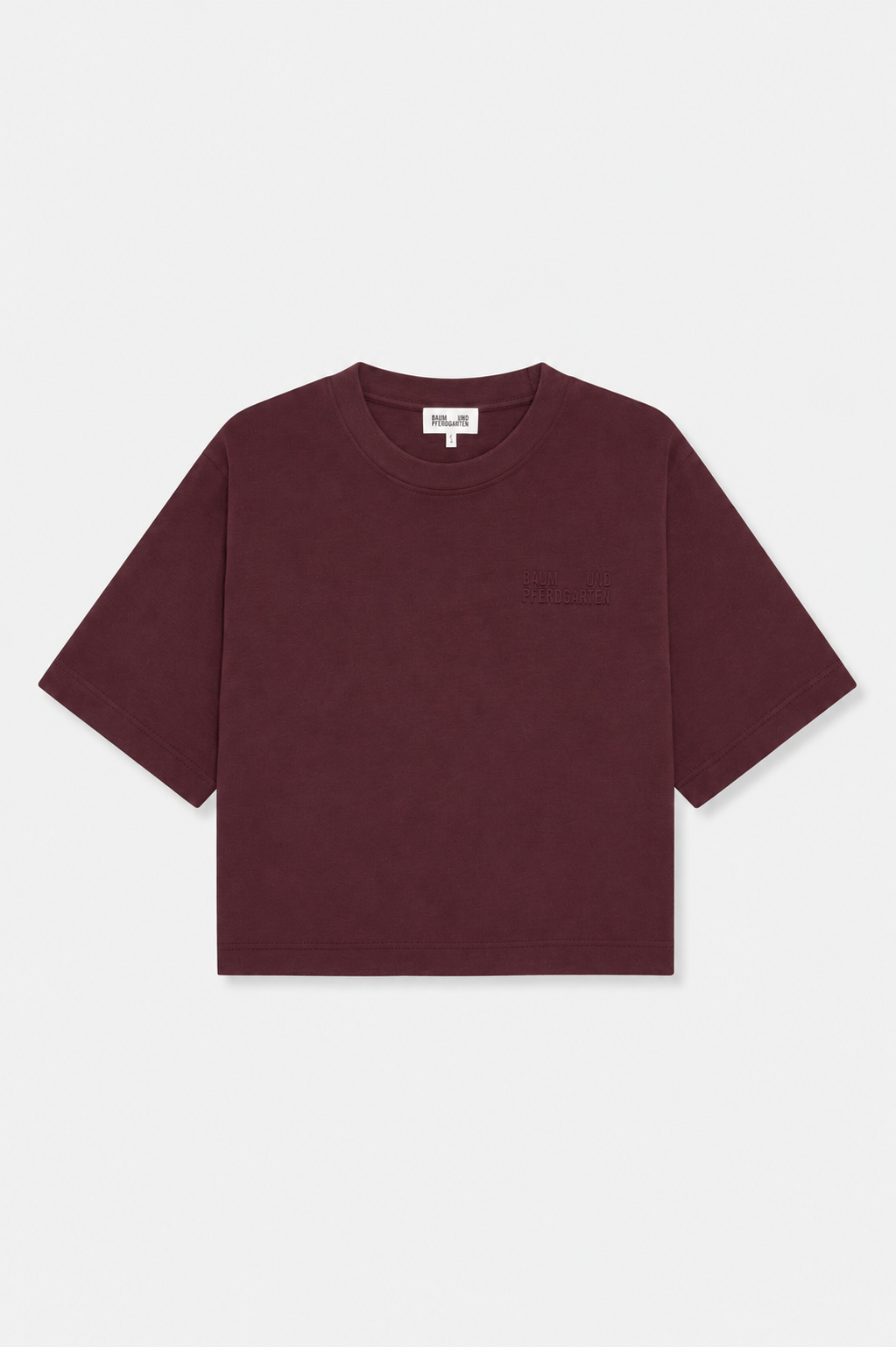 Front view of a burgundy short-sleeved T-shirt with a crew neck and tonal Baum und Pferdgarten lettering on the chest.