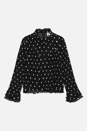 Black sheer, crinkled long-sleeve blouse with white irregular dots, a ruffled high neckline and layered cuffs, shown from the front