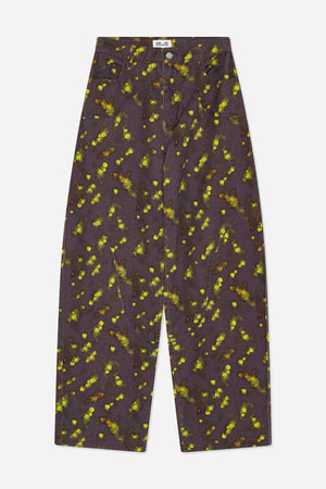 Front view of wide-leg jeans with a dark plum base, scattered yellow-green and rust floral print, curved front seams and pockets.