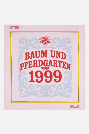 Pale pink square scarf with blue ornamental scrollwork, a yellow border and red Baum und Pferdgarten 1999 lettering