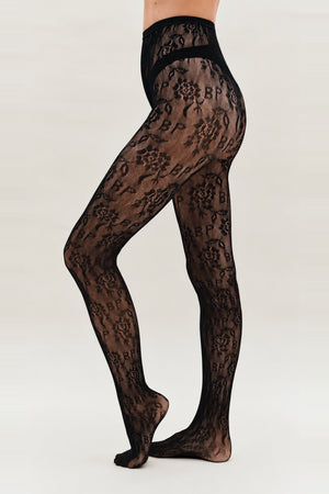 Sheer black floral-pattern tights with a wide waistband and curved opaque hip bands, modeled from waist to feet.